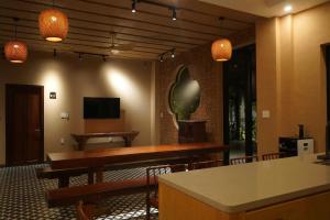 a dining room with tables and chairs and a tv at Aki Eco-villa Hội An in An Bang