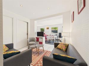 a living room with two couches and a dining room at Piscine chauffée, plage à 700m, maison pour 6 in Pléneuf-Val-André