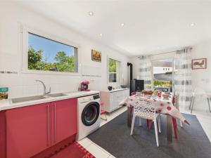 a kitchen with a washing machine and a table at Piscine chauffée, plage à 700m, maison pour 6 in Pléneuf-Val-André
