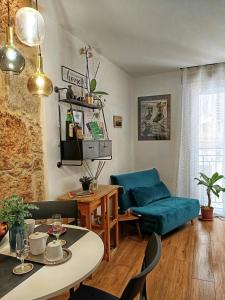 ein Wohnzimmer mit einem Tisch und einem blauen Sofa in der Unterkunft Dimora al Capo in Palermo