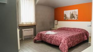una camera da letto con un letto e una parete arancione di Alla Passeggiata a Bussolengo