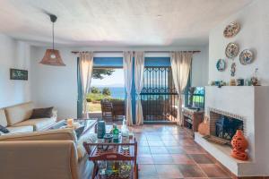 a living room with a couch and a fireplace at Amazing view elegant Maisonette in Kriopigi