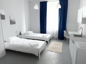 a hotel room with two beds and a sink at MobiRooms - Pokoje i Apartamenty in Wrocław +24 photos
