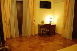 a room with curtains and a table and a television at Palazzo Mascambruno in Cariati