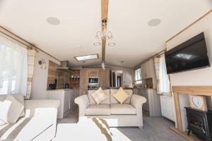 a living room with two couches and a tv in a caravan at The Jetty in Christchurch