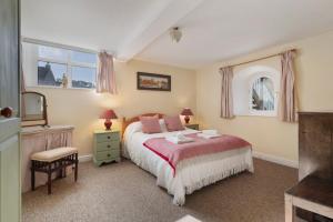 a bedroom with a bed and a chair and windows at Llanfor in Fishguard