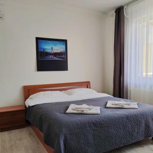 a bedroom with a bed with two towels on it at SAG Riazanska Residence 3 room Free Wi-Fi in Bratislava