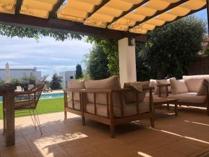 サン・リュイスにあるRoures 13 Villa con piscina privada y ACの- パティオ(パーゴラの下にソファと椅子付)