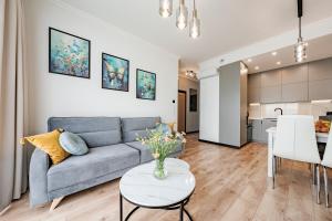 a living room with a couch and a table at Sol Marina by Comfort Apartments in Wiślinka
