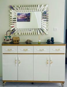 cocina con armarios blancos y espejo en Darna tangier, en Tánger