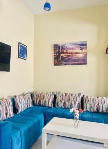Un sofá azul en una sala de estar con una mesa. en Darna tangier, en Tánger