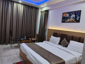 a hotel room with a large bed and a chair at Hotel Amansara in Lucknow