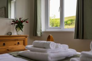 een kamer met handdoeken op een bed en een raam bij Brambly Cottage in Whitby