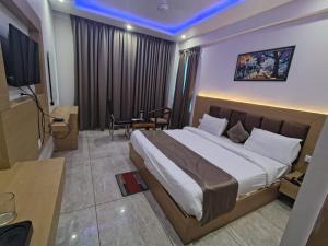 a hotel room with a large bed and a table at Hotel Amansara in Lucknow