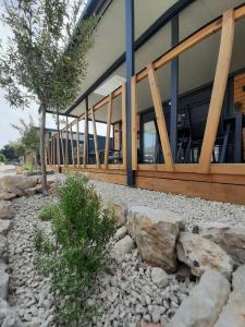 a building with a tree and rocks in front of it at Mobile homes Laguna, beach Porat, Drage in Drage