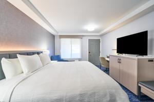 a hotel room with a large bed and a flat screen tv at The Bridgeway in Bourne