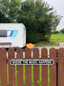 a fence with a sign that says where the magic happens at Seaview Retreat & Sauna at An Acre By The Sea in Clonakilty