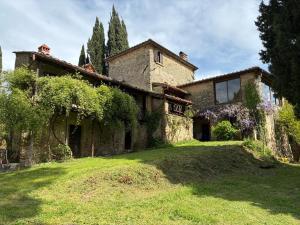 a large stone house on a grassy field at Agriturismo Le Pozze in Dicomano