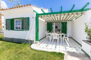 a small white house with a table and chairs at Campo Golf 75 by VillaGranCanaria in Maspalomas