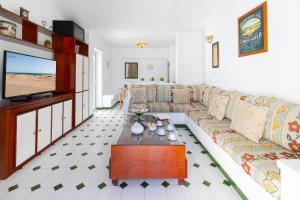 a living room with a couch and a tv at Campo Golf 75 by VillaGranCanaria in Maspalomas