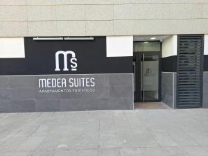 a sign for a meier suites building with a door at Medea Suites Apartamentos in Mérida