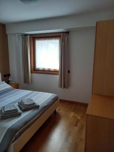 a bedroom with a bed and a window with towels at Casa Lorena in Piatta