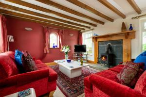 Una sala de estar con muebles rojos y chimenea. en Forge 2 bedrooms, en Beverley