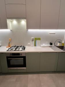 a kitchen with white cabinets and a stove top oven at Apartament Aleje in Dąbrowa Górnicza +7 photos