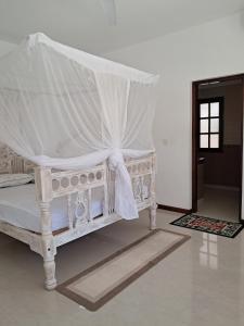 a white bed with a canopy in a room at J and R Villa, Watamu in Watamu +24 photos