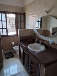 a bathroom with a sink and a mirror and a toilet at J and R Villa, Watamu in Watamu
