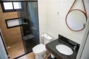 a bathroom with a toilet and a sink and a shower at Condomínio Pagani in Foz do Iguaçu +32 photos