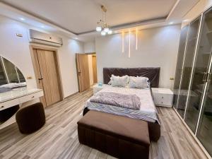 a bedroom with a large bed and a mirror at House in 6th Of October