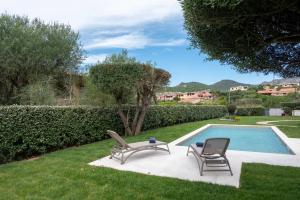 two chairs and a table next to a swimming pool at Summer Luxury Apartment Adults Only in Olbia