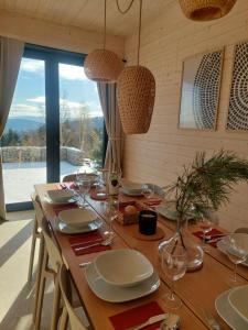 a wooden table with plates and wine glasses on it at GOLaskowa in Laskowa
