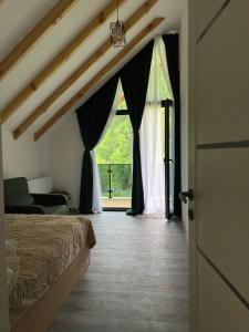 a bedroom with a bed and a large window at MTA house - Borjomi in Borjomi