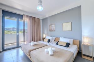 Dos camas en una habitación con una gran ventana. en Filerimos Panorama Villa, en Pastida 34 fotos más