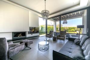 sala de estar con sofá, sillas y chimenea en Filerimos Panorama Villa, en Pastida