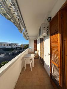 a balcony with a table and a view of a street at Perla marina in Torre dell'Orso