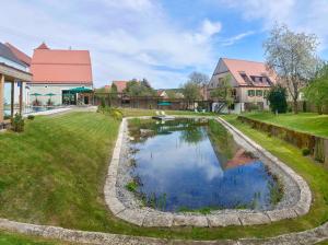 a garden with a pond in front of a building at Romantik Hotel Zum Klosterbräu in Neuburg an der Donau