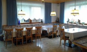 a dining room with a table and chairs and windows at Garni Schwarzenstein in Campo Tures