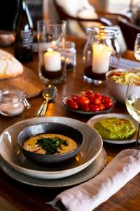a table with a bowl of food on a table with candles at Villa by the Sea in Mala