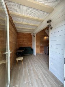 a living room with a green couch and a wooden ceiling at Duplex - forêt de Rambouillet in Gambaiseuil +1 photo