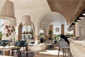 a lobby with chairs and tables and a bar at Cala Ponte, a Tribute Portfolio Hotel in Polignano a Mare