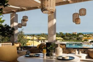 a dining room with a view of a pool at Cala Ponte, a Tribute Portfolio Hotel in Polignano a Mare