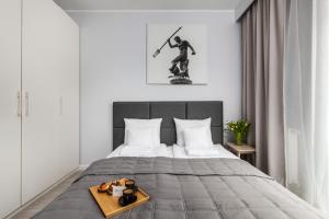 a bedroom with a bed with a tray of toys on it at Nowa Motława Residence by HappyStay in Gdańsk +63 photos