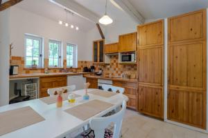 a kitchen with wooden cabinets and a table and chairs at Chalet En Bois in Saint-Cernin-de-lʼHerm