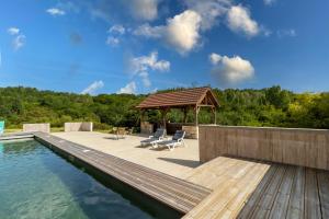 a swimming pool with a deck and a gazebo at Chalet En Bois in Saint-Cernin-de-lʼHerm