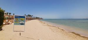 a beach with a sign in the sand and the water at Red Sea Serenity in Sharm El Sheikh +84 photos