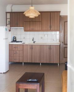 a kitchen with wooden cabinets and a table in it at KAJU ROOMS Bozburun in Bozburun