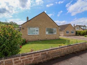 a brick house with a lawn in front of it at Hillside in Cheltenham